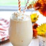 Gingerbread Pumpkin Smoothie in a glass with whipped cream and orange straws