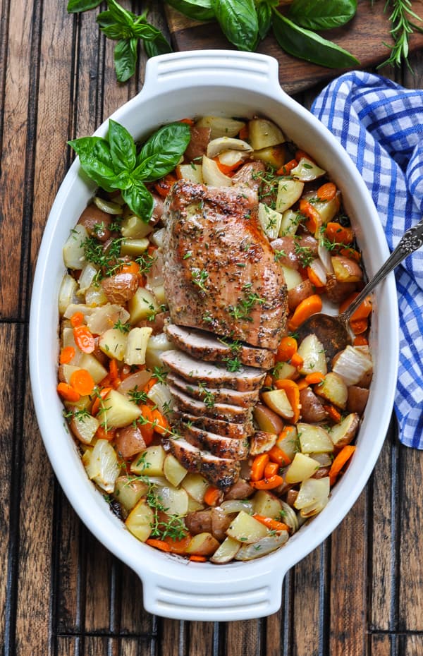 Overhead image of Garlic and Herb Pork Tenderloin with roasted vegetables in white baking dish