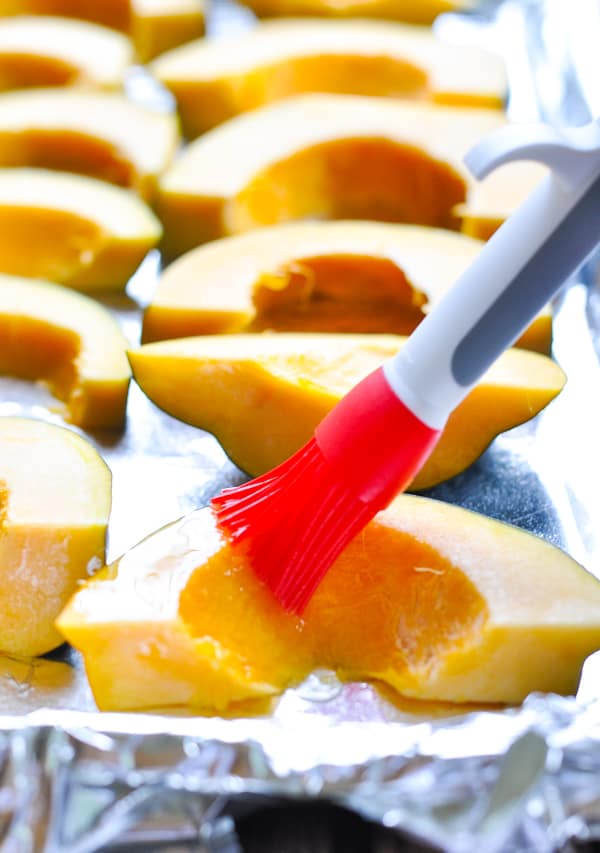 Brushing melted butter on acorn squash slices