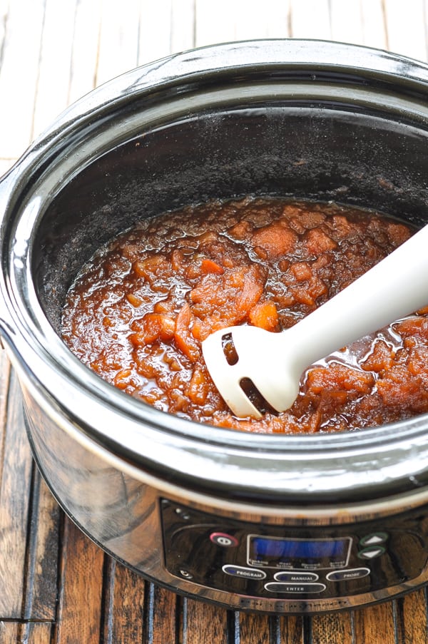 Immersion blender in slow cooker with apple butter