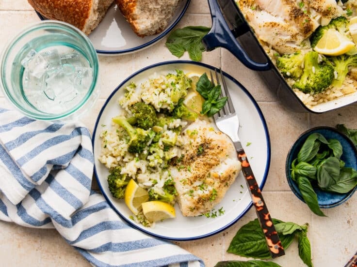 Horizontal overhead image of a plate of baked fish and rice with broccoli.