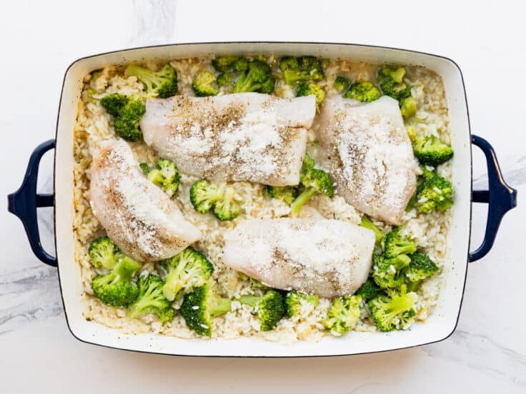 Adding the fish to the baking dish.