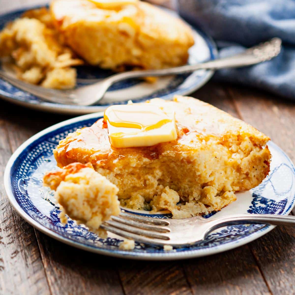 Square side shot of spoon bread on a blue and white plate.