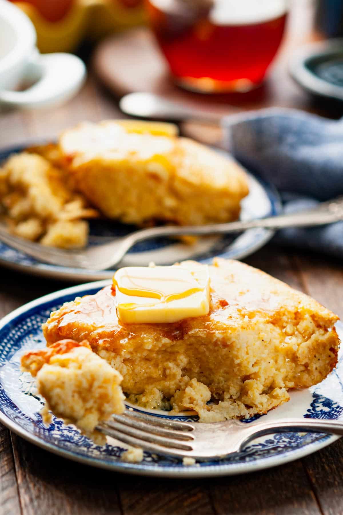 Side shot of a fork taking a bite of Virginia spoon bread on a plate.