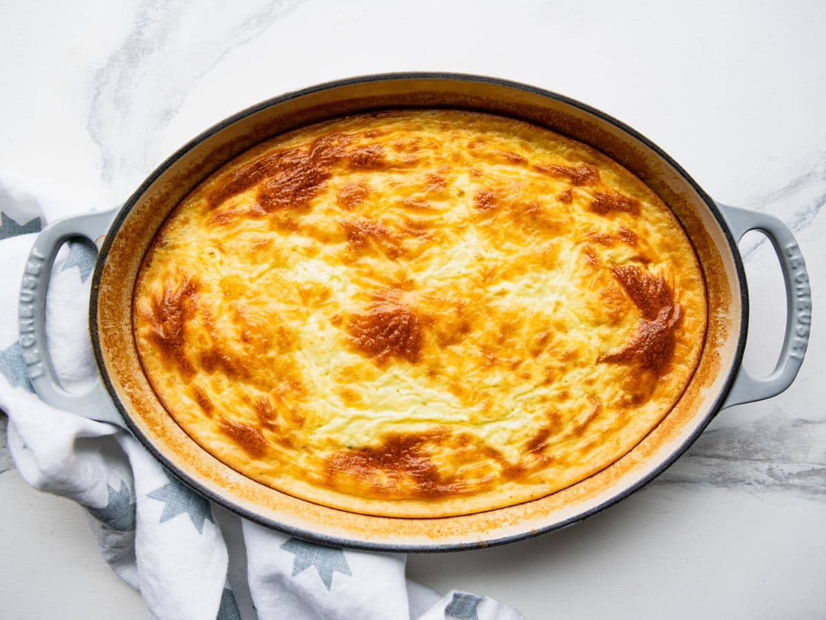Baked spoon bread in a cast iron pan.