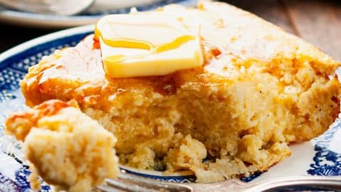 Close up square image of Southern spoon bread on a plate.