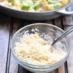 Buttered panko breadcrumbs mixed with Parmesan cheese in a glass bowl