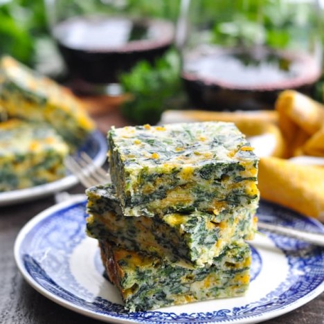 Appetizer plates full of cheesy spinach squares.