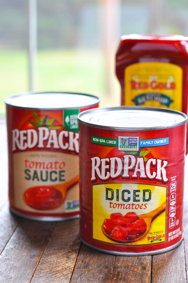 A can of Redpack tomato sauce, diced tomatoes, and a bottle of Redpack ketchup - all necessary ingredients for this chili con carne recipe!