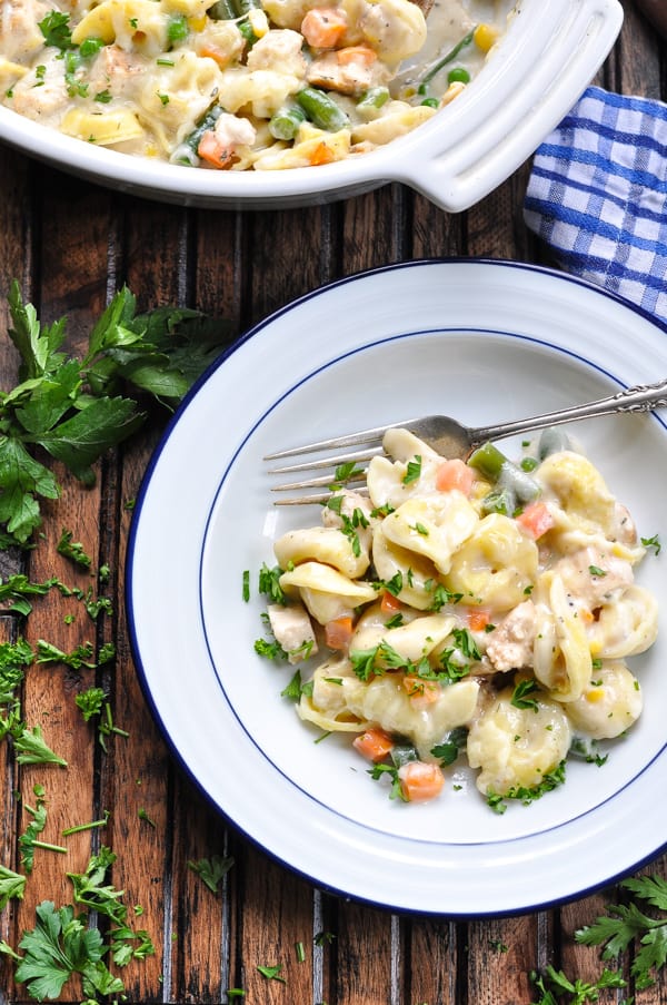 Baked Tortellini Alfredo with Chicken and Vegetables in a white bowl with fork