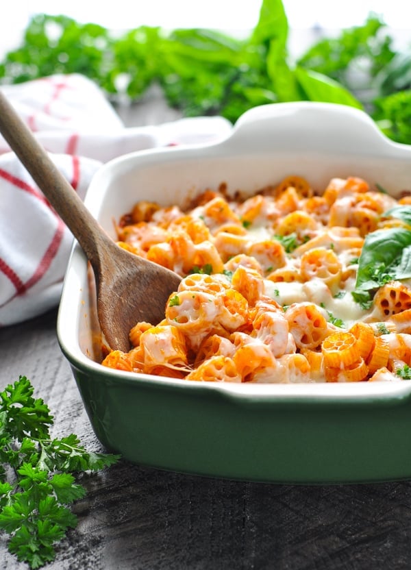 Healthy pasta bake in casserole dish with wooden spoon