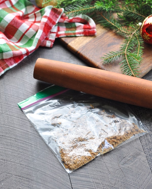 Crushed gingersnap cookie in bag with rolling pin