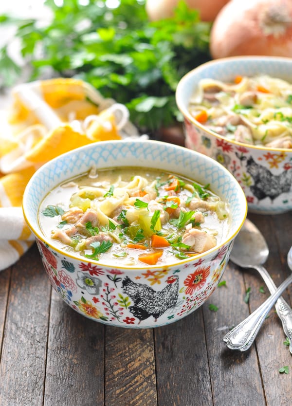 Bowls of homemade turkey noodle soup garnished with fresh parsley