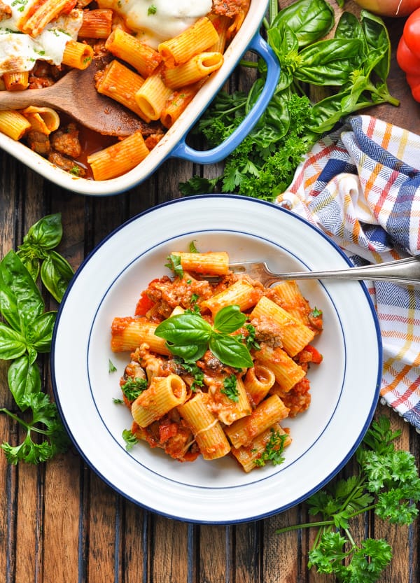 Overhead image of bowl of Italian Sausage Pasta Bake with basil and parsley