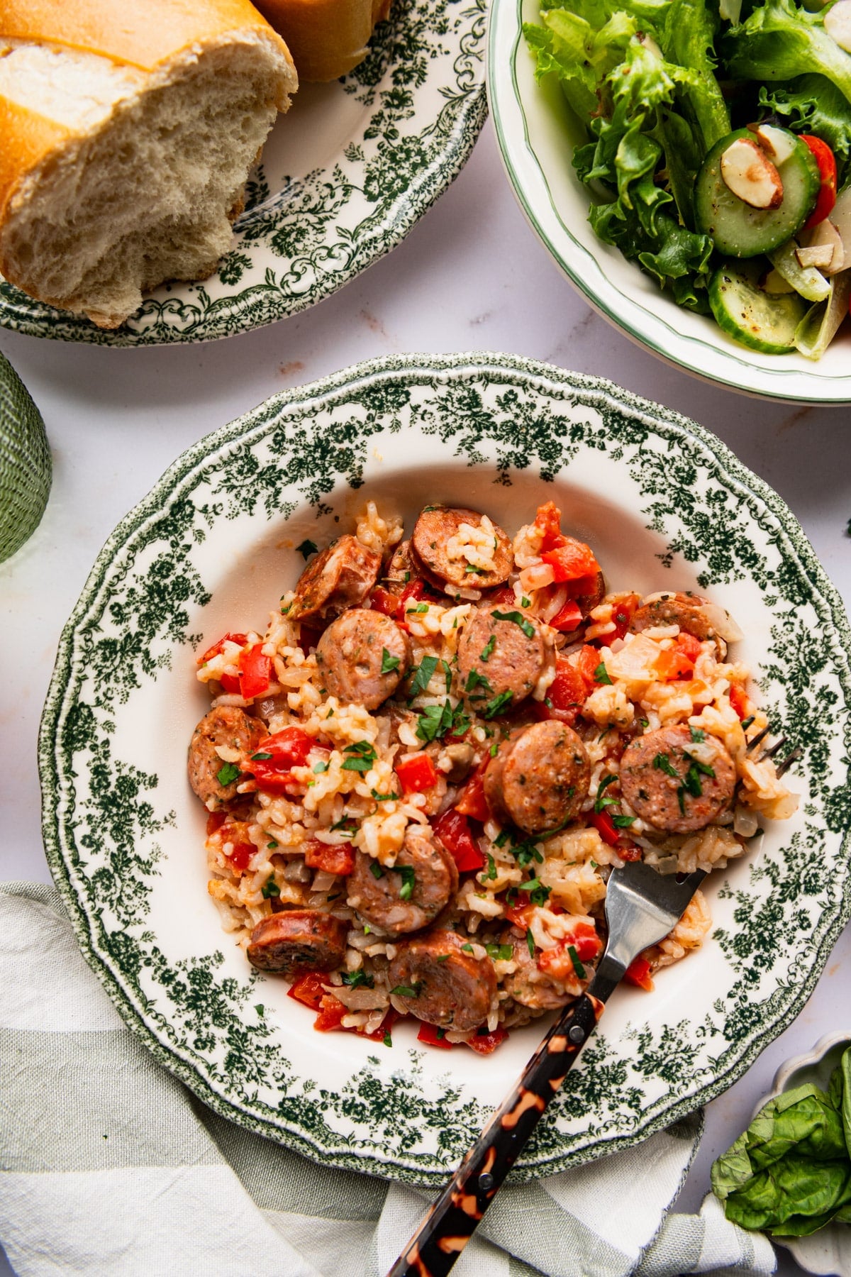 Overhead shot of Italian sausage and rice casserole in a green and white serving bowl.