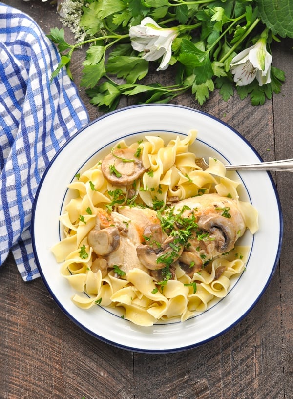 Overhead image of bowl of sliced chicken breast and noodles topped with creamy mushroom sauce