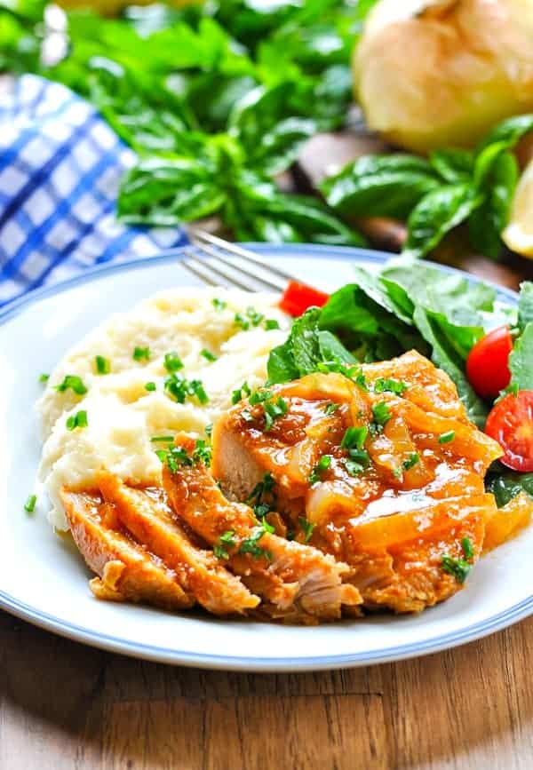 Crock Pot Smothered Pork Chops served on a white plate with blue trim