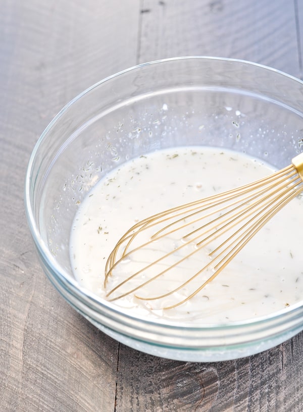Creamy mushroom sauce for chicken and mushroom casserole in a glass bowl with whisk