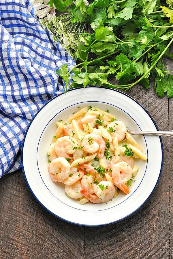 Overhead image of bowl of Shrimp Alfredo surrounded by fresh parsley