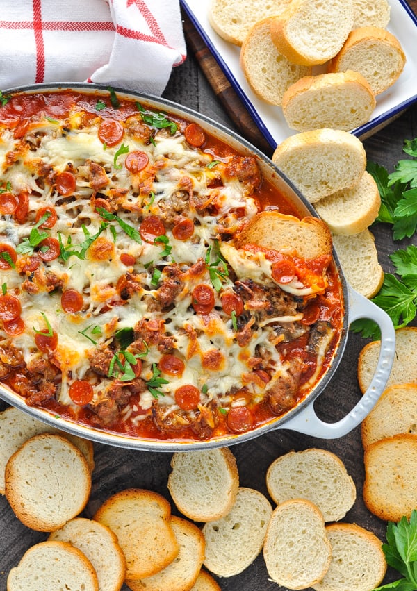 Overhead image of easy pizza dip surrounded by bread for dipping