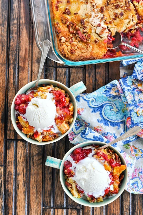 Overhead image of two bowls of cherry dump cake with vanilla ice cream on top