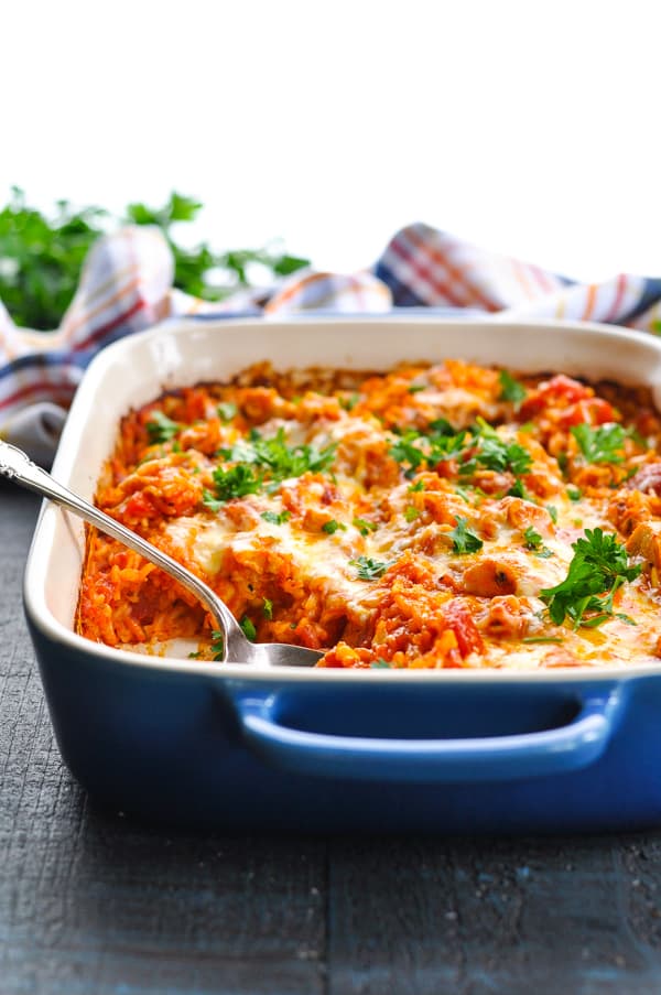 Italian Chicken and Rice Casserole in blue baking dish garnished with fresh parsley