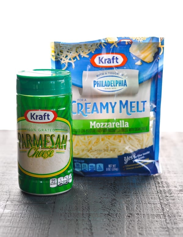 Can of grated Parmesan and bag of shredded mozzarella cheese