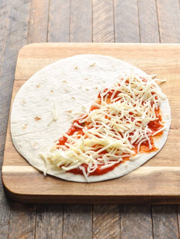 Mozzarella cheese sprinkled onto tortilla