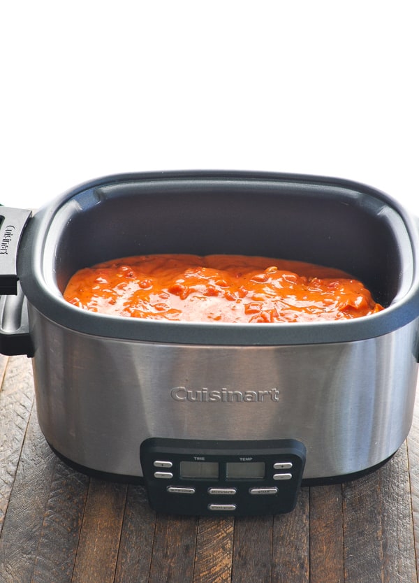 Tomato sauce poured on top of chicken in slow cooker