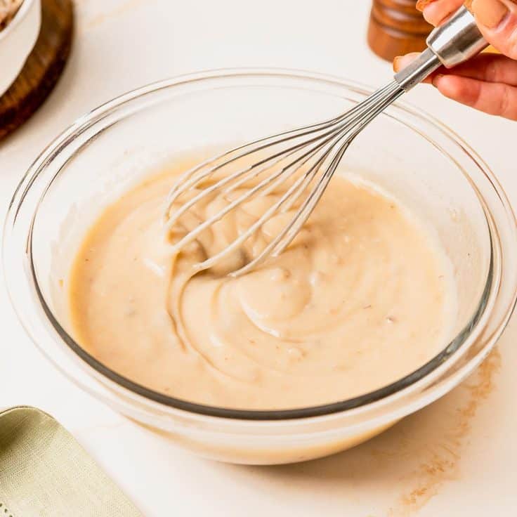 Whisking together the creamy sauce for slow cooker meatball stroganoff.