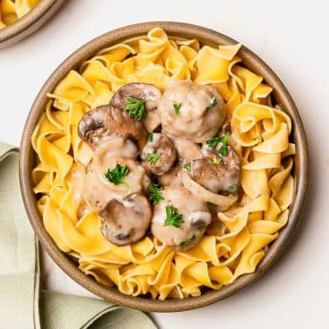 Close up square shot of a bowl of slow cooker meatball stroganoff with egg noodles.