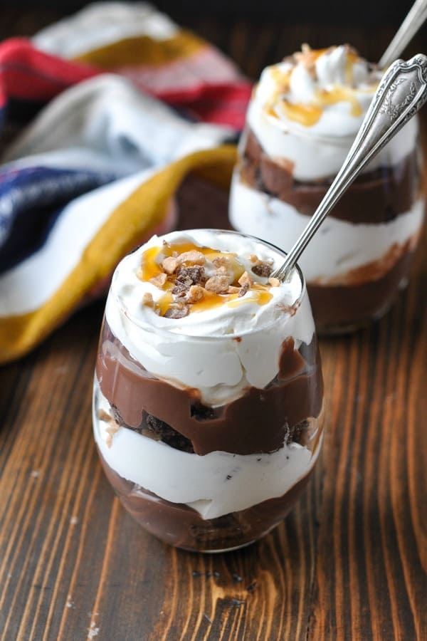 Easy chocolate trifle with layers of brownies and whipped cream topped with caramel sauce and toffee Heath Bars
