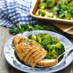 Front view of sliced garlic parmesan chicken with broccoli on a plate