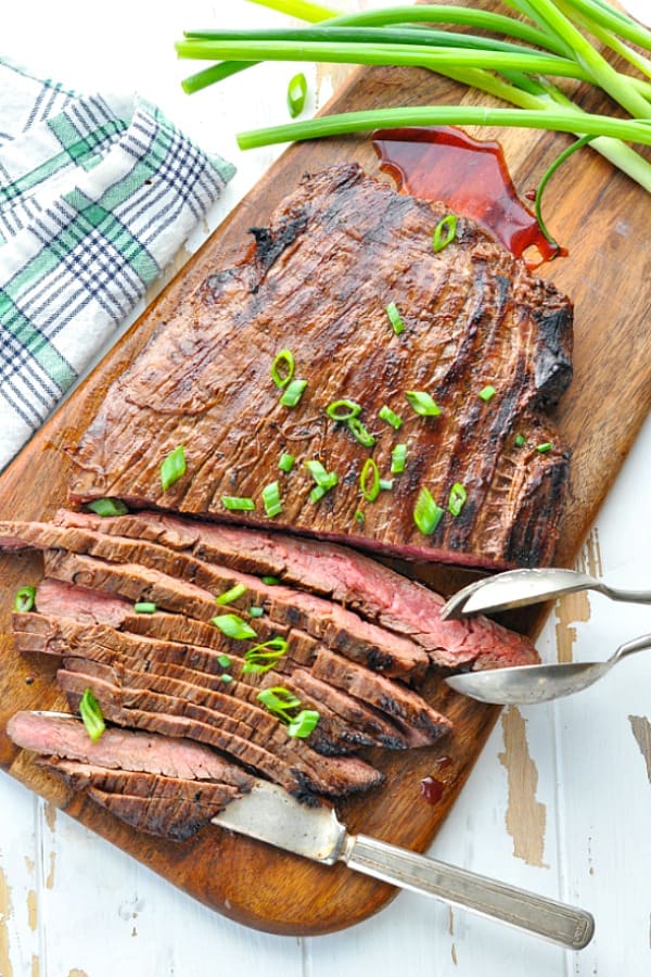 Overhead shot of sliced marinated flank steak on a cutting board