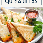 Side shot of pizza quesadillas on a white plate with text title box at top