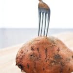 Pricking a sweet potato with a fork