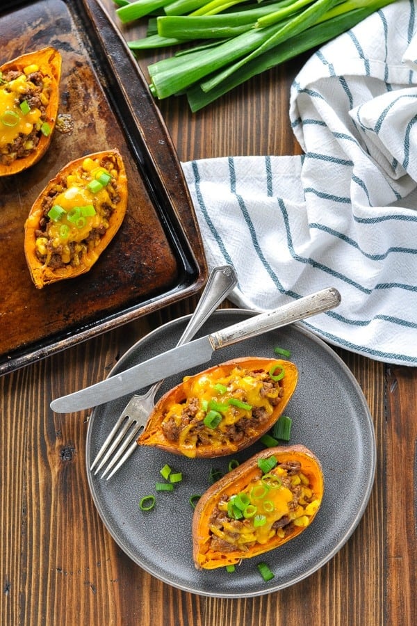 Overhead shot of stuffed potatoes on a plate and on a baking sheet