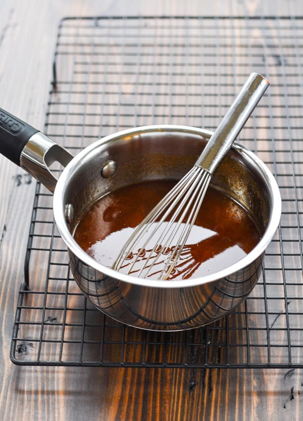 Apricot sauce for crock pot pork roast in a small saucepan with whisk