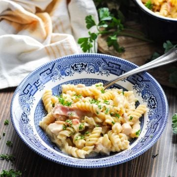 Chicken bacon ranch pasta in a bowl with fresh parsley in the background