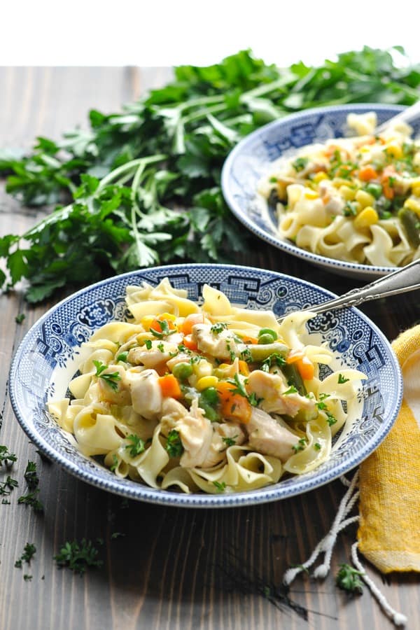 Front view of two bowls of creamy garlic chicken with vegetables and noodles