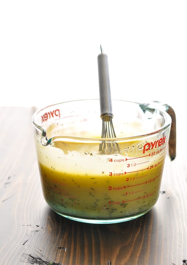 Cream sauce in large measuring cup with whisk