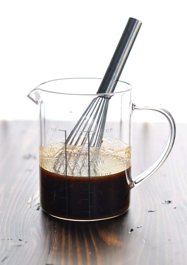 Moo shu chicken sauce in glass measuring cup with whisk