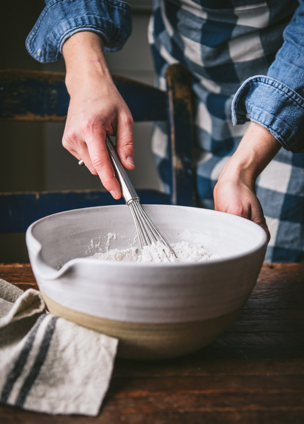 Whisking together dry ingredients in a white bowl
