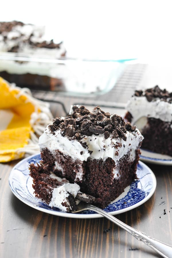 Piece of Oreo Poke Cake on a plate with a fork