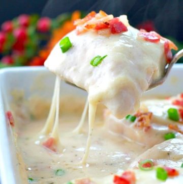 Lifting cheesy chicken breast from baking dish