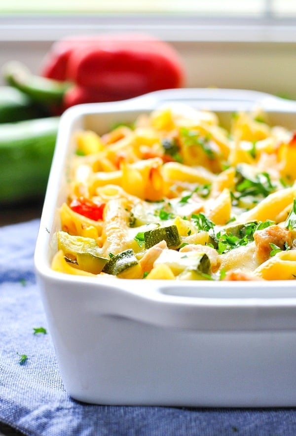 A close up shot of summer pasta with zucchini in a white casserole dish