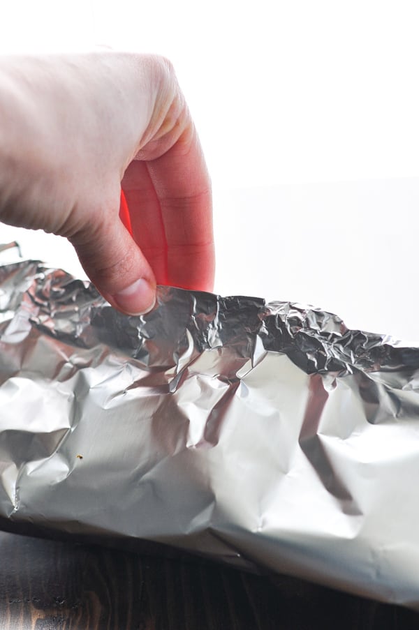 Closing and sealing packet of salmon baked in foil