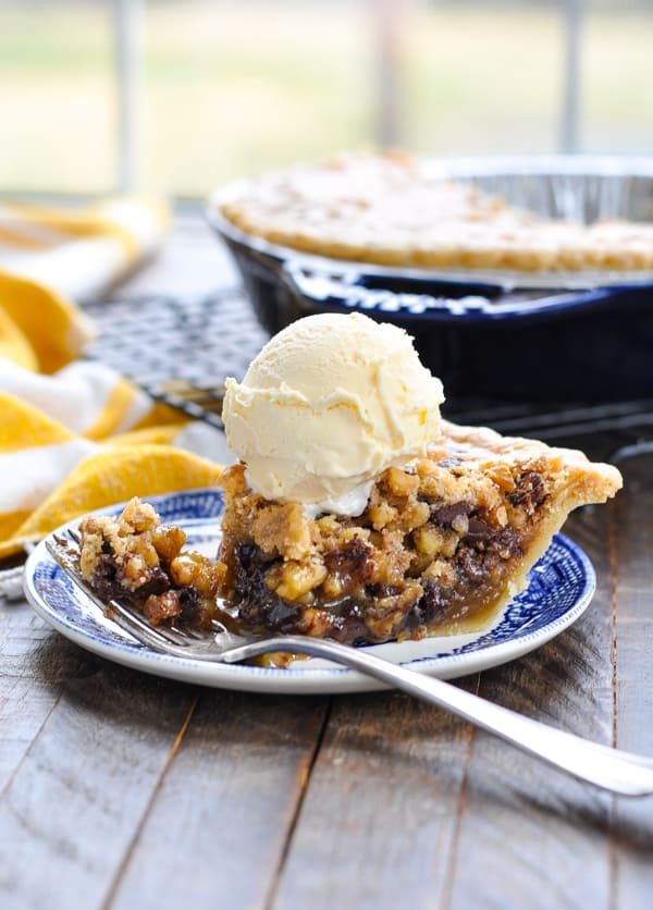 Piece of Chocolate Pecan Pie topped with a scoop of vanilla ice cream