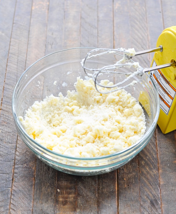 Butter mixture with hand mixer in a glass mixing bowl