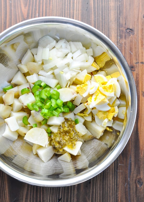 Overhead shot of potato salad ingredients in large metal bowl